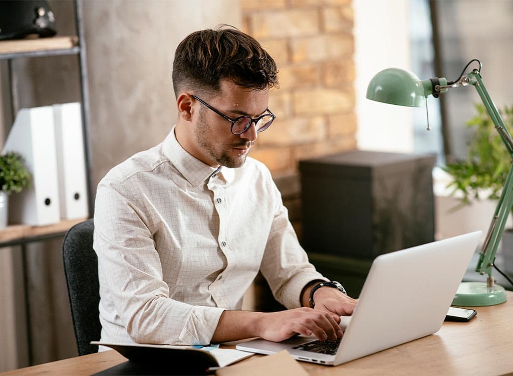 jeune homme travaillant sur son ordinateur portable