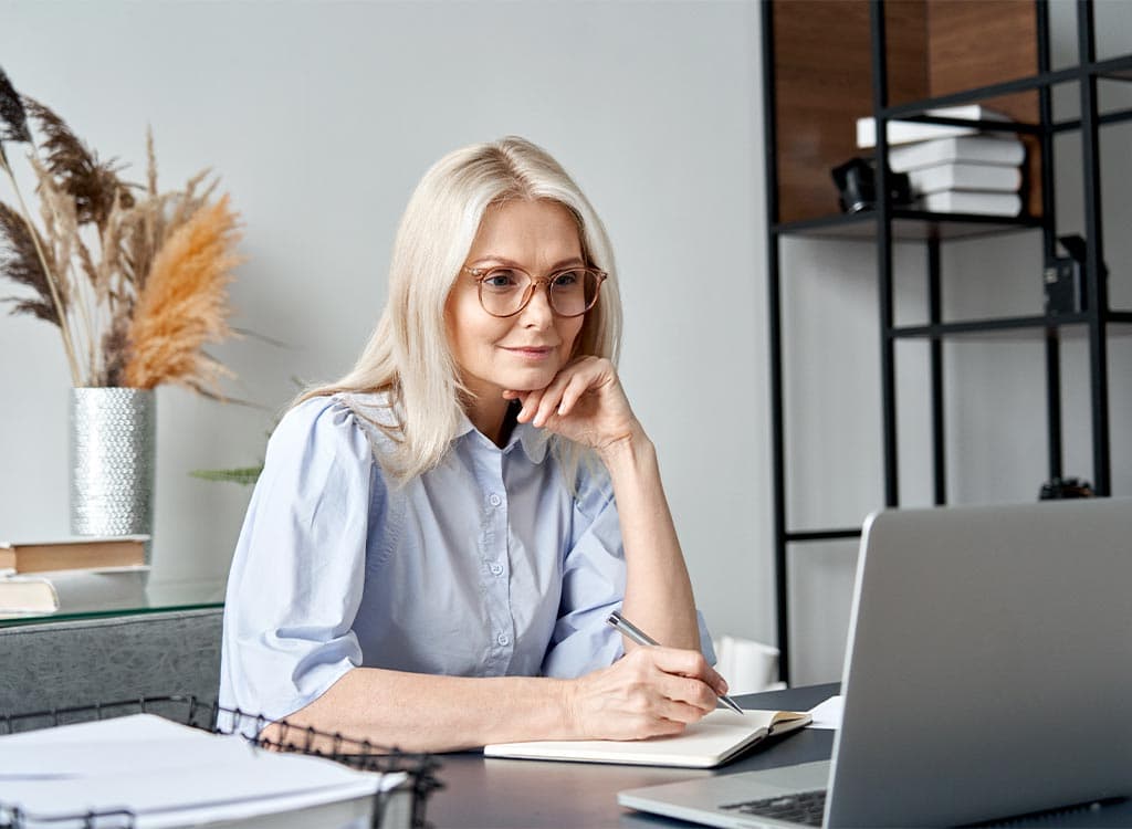 femme à la quarantaine travaillant sur son bureau